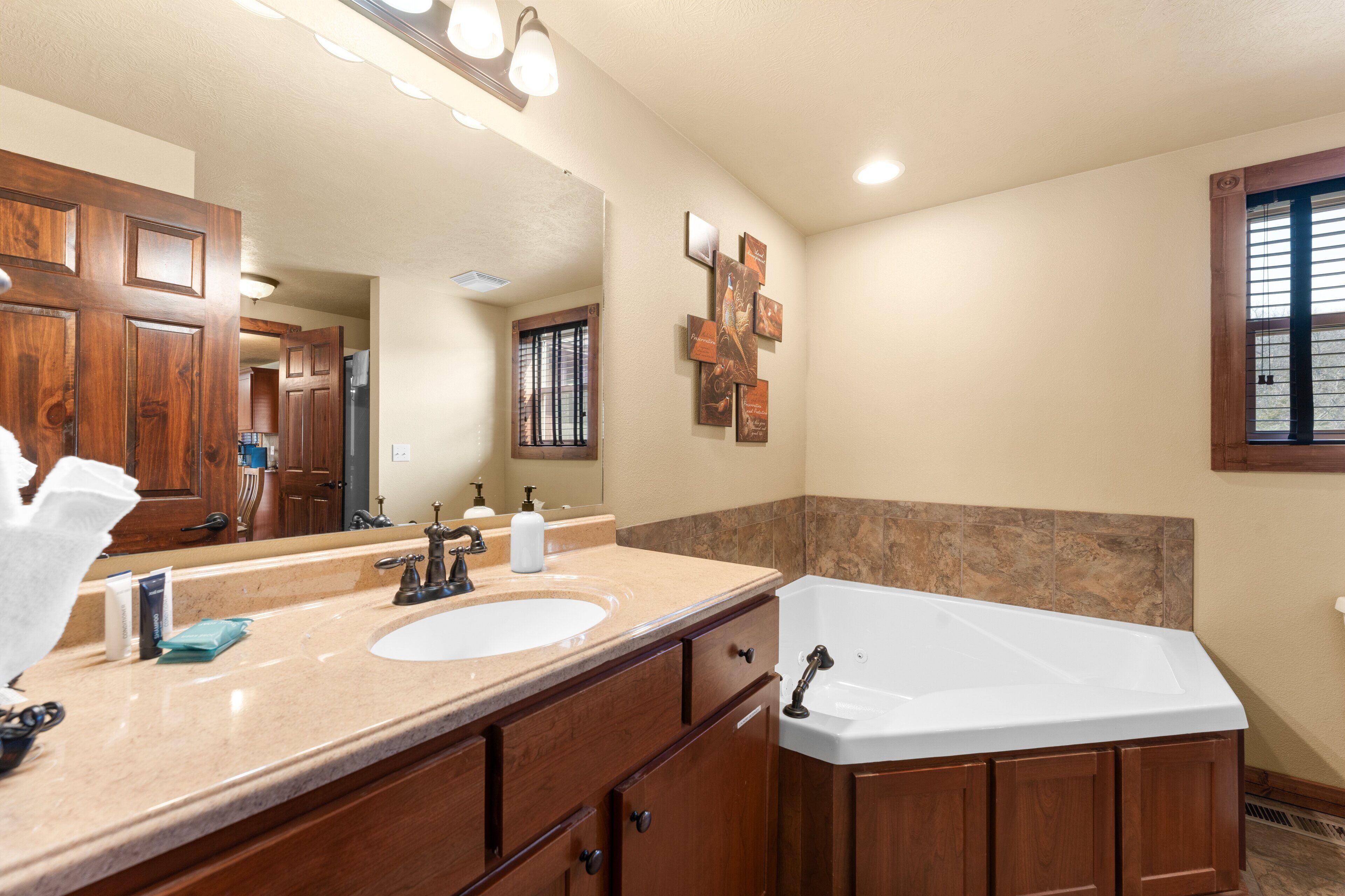 A bathroom with a double sink, vanity, and a large bathtub.