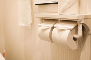 Dispensador de papel higiénico con dos rollos fijado a la pared.