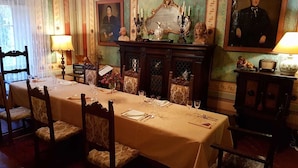 Comedor con una larga mesa dispuesta para una comida, rodeada de sillas.