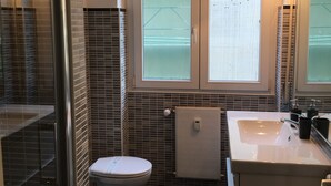 A bathroom with a toilet, a sink, and a shower. - Vatican Central Suites (Rome)