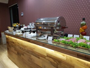 A buffet counter with a variety of food items, including salads, meats, and beverages. - Redline Hotel (Tbilisi)