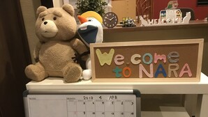 A calendar with a 'Welcome to NARA' sign and a teddy bear. - Guest House One More Heart at NARA DEN - Hostel (Nara)