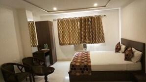 Una habitación de hotel con una cama, un escritorio y una silla.