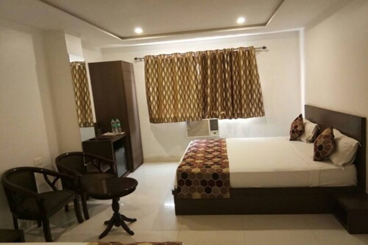 A hotel room with a bed, a desk, and a chair.