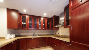 A kitchen with wooden cabinets, a countertop, and a sink. - Piks Key - Miska 3 (Dubai)