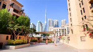 A courtyard with a playground, surrounded by buildings with balconies and a view of the Burj Khalifa. - Piks Key - Miska 3 (Dubai)