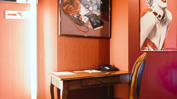 Une pièce comprenant un bureau, une chaise et deux affiches encadrées accrochées au mur.