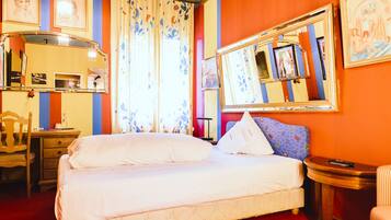 Een hotelkamer met een bed, een bureau, een stoel, een spiegel en een plafond met een zondecoratie.