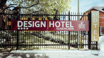Ein schwarzer Metallzaun mit einem Schild, auf dem ‘DESIGN HOTEL EUSKIRCHEN’ steht.