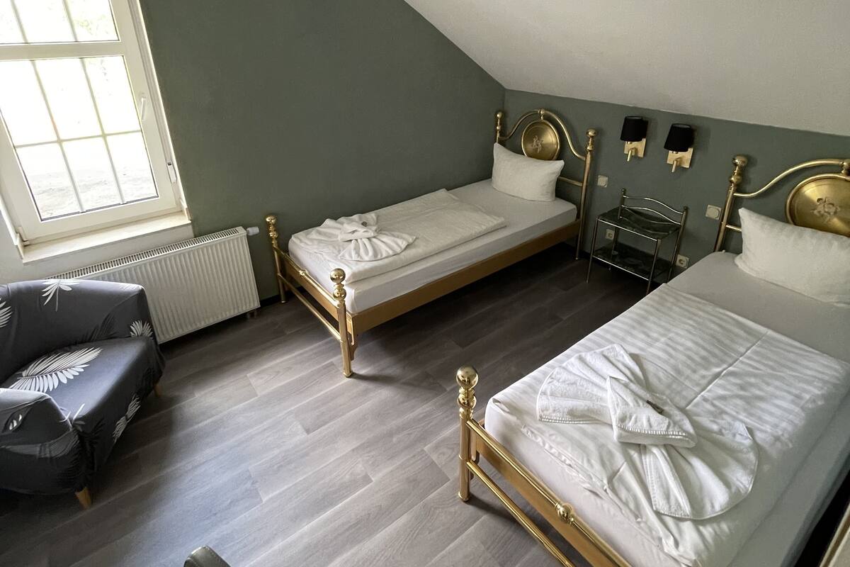 Un dormitorio con dos camas, un escritorio y una silla.