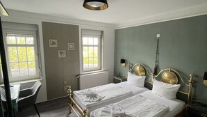 Un dormitorio con una cama doble, dos mesitas de noche, un escritorio y una silla.