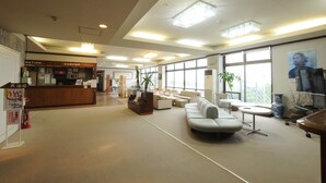 A spacious lobby with a reception desk, seating area, and large windows. - HOTEL Akenohoshi (Muroto)