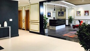 Un moderno vestíbulo de hotel con mostrador de recepción, zona de estar y mostrador de atención al cliente.