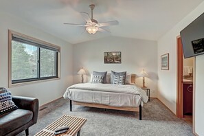 A bedroom with a bed, two bedside lamps, a ceiling fan, a window, and a TV. - 732b Meadow Creek 2 Bedroom Townhouse by RedAwning (Frisco)