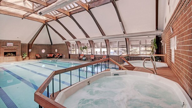 An indoor swimming pool with a hot tub, wooden deck, and brick walls. - 732b Meadow Creek 2 Bedroom Townhouse by RedAwning (Frisco)