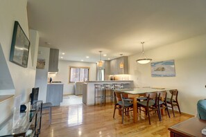 A modern kitchen with wooden countertops, a central island, and pendant lighting.