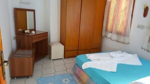 Un dormitorio con cama, cómoda, espejo y armario.