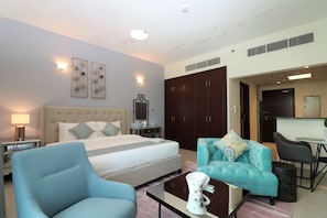 Ein Hotelzimmer mit Bett, Sofa, Couchtisch, Fernseher und Kleiderschrank.