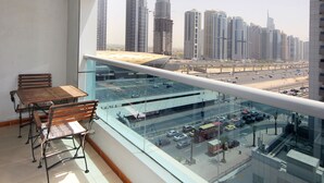 Un balcon avec vue sur la ville, une table et deux chaises.