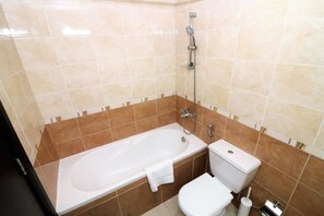 A bathroom with a bathtub, toilet, and shower. - Piks Key - Dubai Gate 1 (Dubai)
