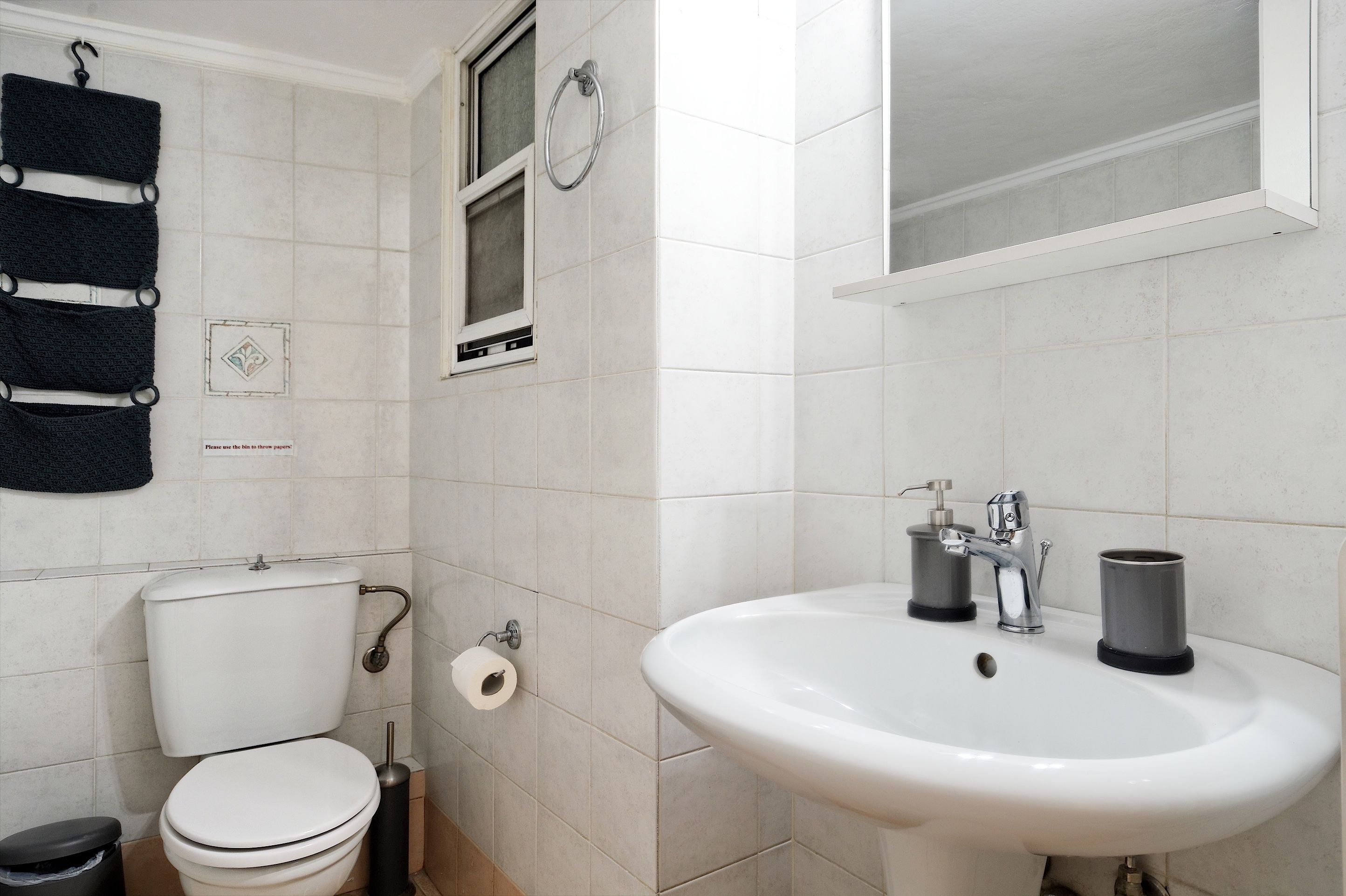 Ein Badezimmer mit Toilette, Waschbecken und Handtuchhalter.