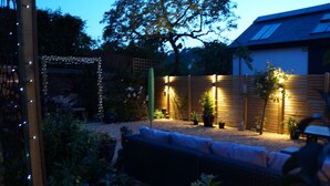 A garden with a wooden fence, a bench, and potted plants. - Brookdale B&B (Wadebridge)