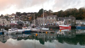 A harbor with boats docked, buildings, and a calm water surface reflecting the surroundings. - Brookdale B&B (Wadebridge)