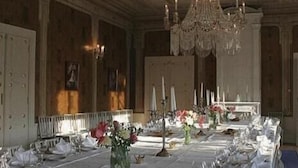 A formal dining room with a long table set for a meal, elegant chandeliers, and classic decor. - Bäckaskog Slott (Fjalkinge)