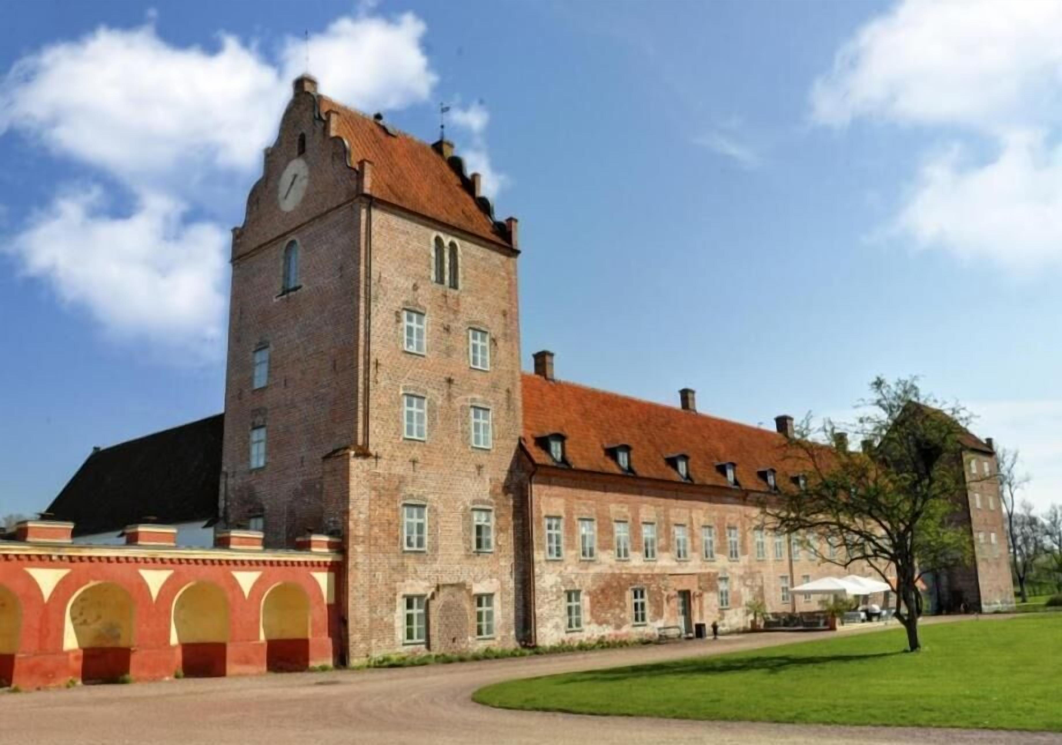 A large, historic building with a prominent tower and multiple windows.