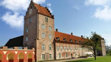 A large, historic building with a prominent tower and multiple windows.