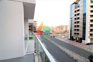 A modern building with a glass facade and a balcony overlooking a wide street. - Piks Key - Binghatti (Dubai)