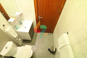A bathroom with a toilet, sink, and shower area. - Piks Key - Binghatti (Dubai)
