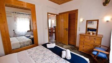 Un dormitorio con cama, cómoda, espejo y silla.