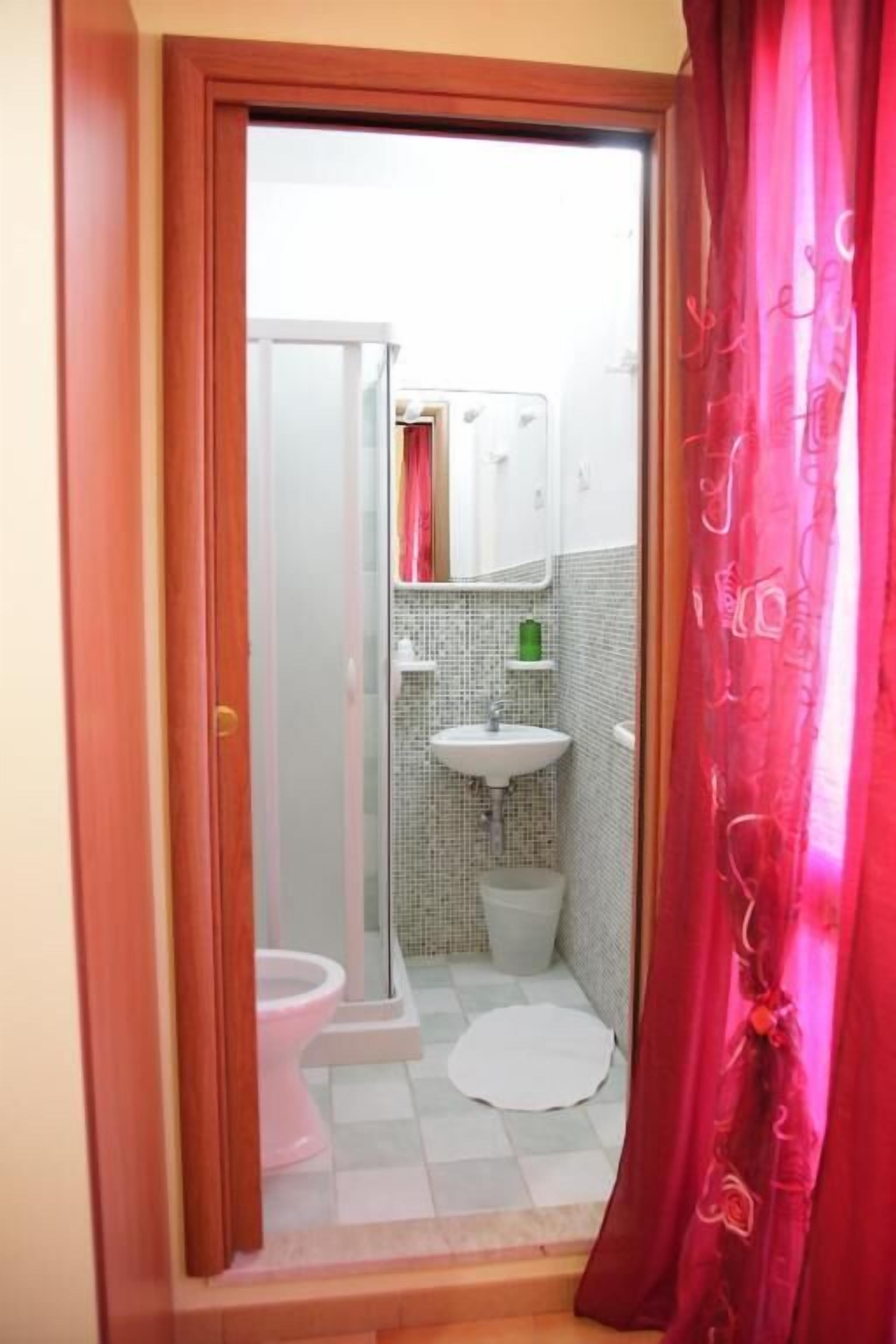 A bathroom with a toilet, sink, and shower area.