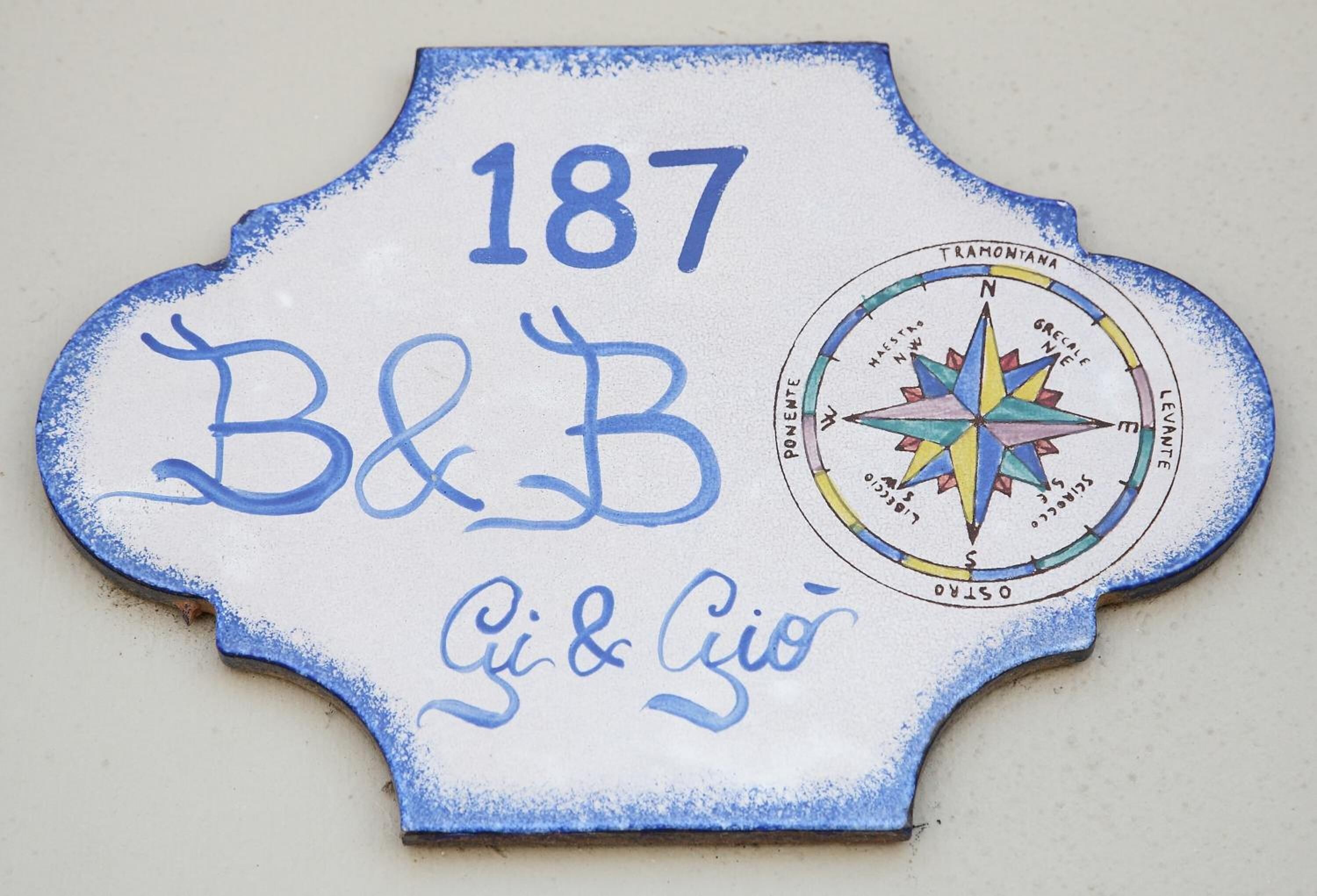 Un letrero decorativo con el número 187, B&B, y los nombres Gi & Gio.