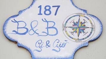 Un letrero decorativo con el número 187, B&B, y los nombres Gi & Gio.
