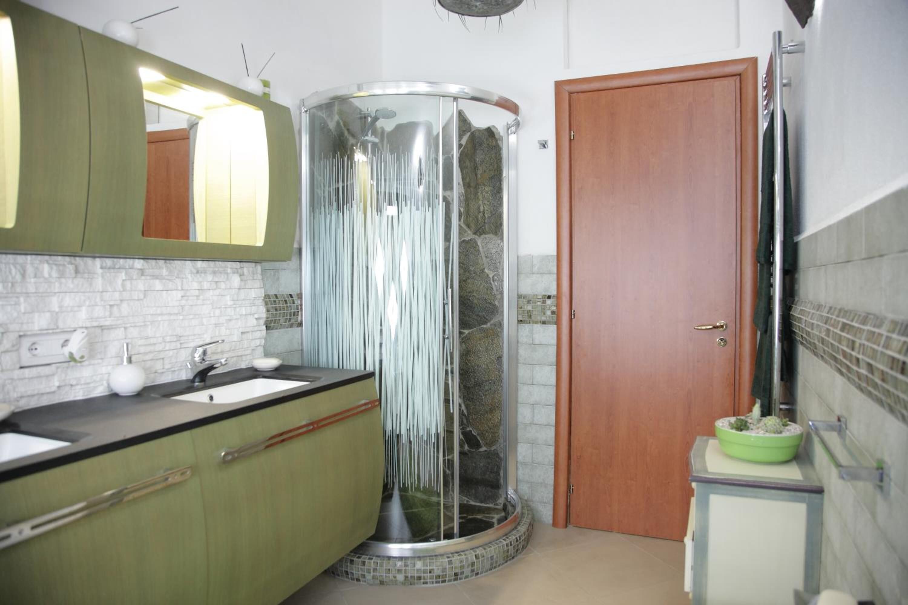A bathroom with a shower, sink, and mirror.