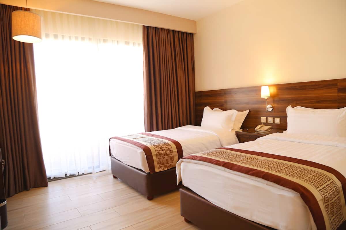 deluxe twin room, multiple beds, smoking, partial sea view | in-room safe, desk, soundproofing, iron/ironing board