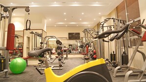 A gym with various exercise equipment, including treadmills, weight machines, and a green exercise ball. - Lacosta Hotel (Aqaba)