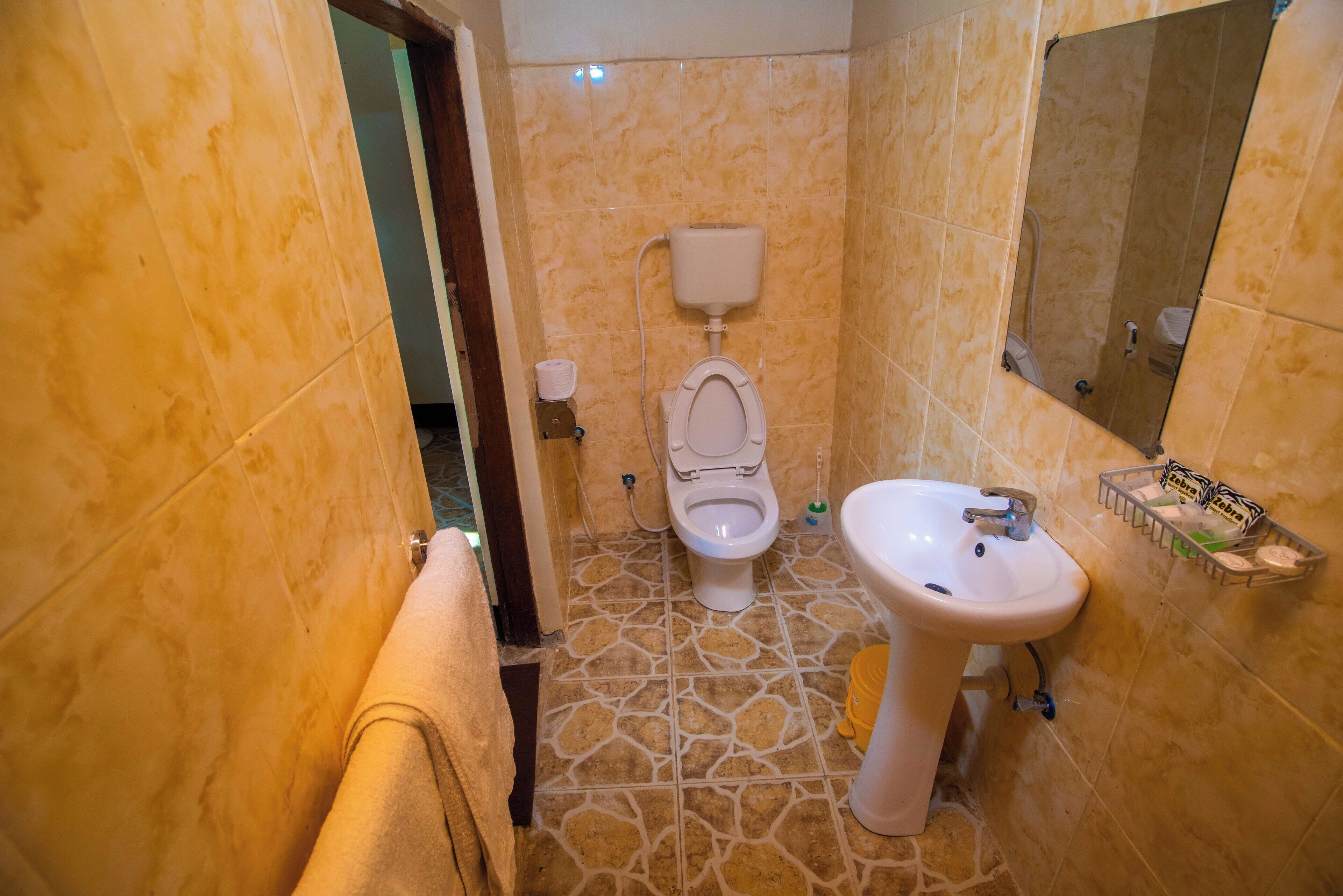 Un baño con inodoro, lavabo y espejo.
