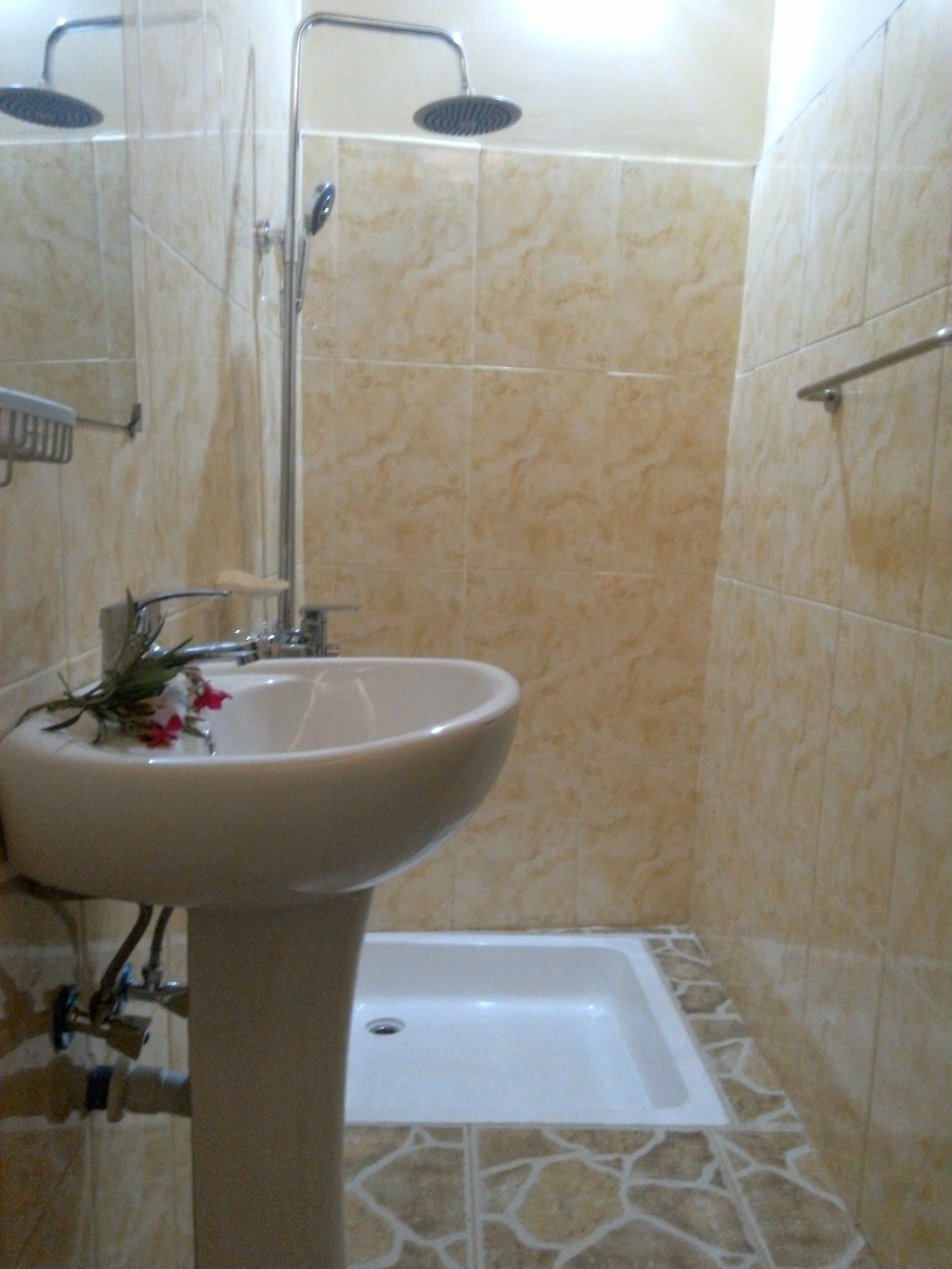 A bathroom with a pedestal sink, a shower, and a bathtub.
