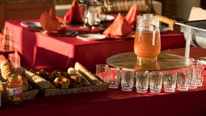 A table set with a pitcher of iced tea, glasses, bread, and condiments.