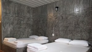 A hotel room with two beds, each with white linens and pillows, against a textured gray wall. - Happy Home Resort (Khlong Yai)