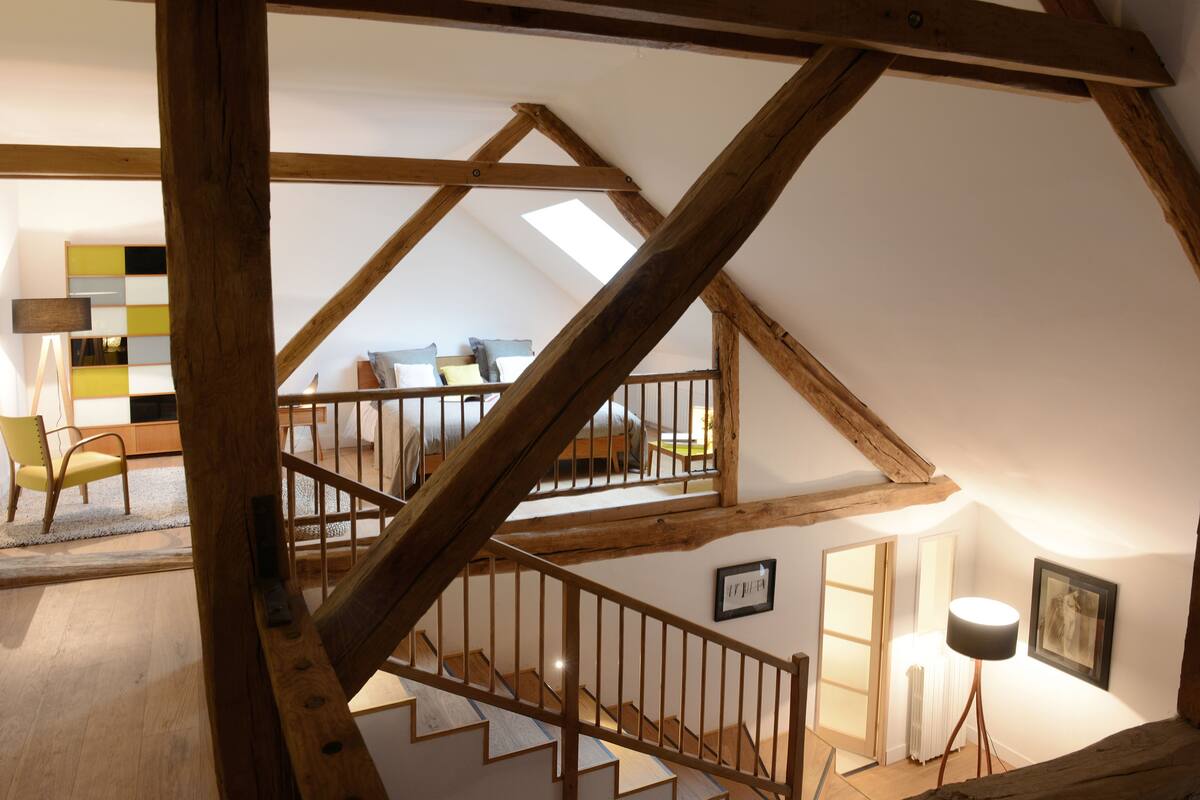 Una escalera de madera con vistas a un dormitorio.