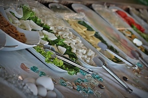 A buffet table with various food items and utensils.