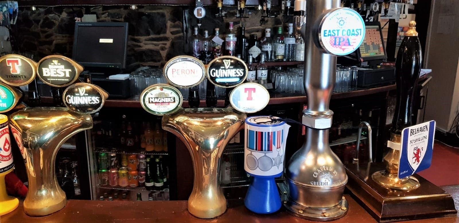 Un bar con varias cañas, incluyendo marcas como Guinness y Peroni.