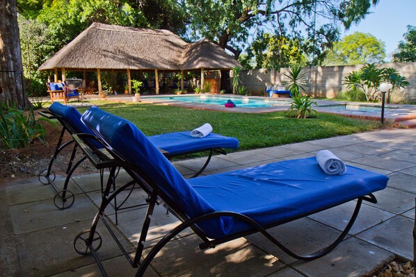 Piscina externa, guarda-sóis, espreguiçadeiras