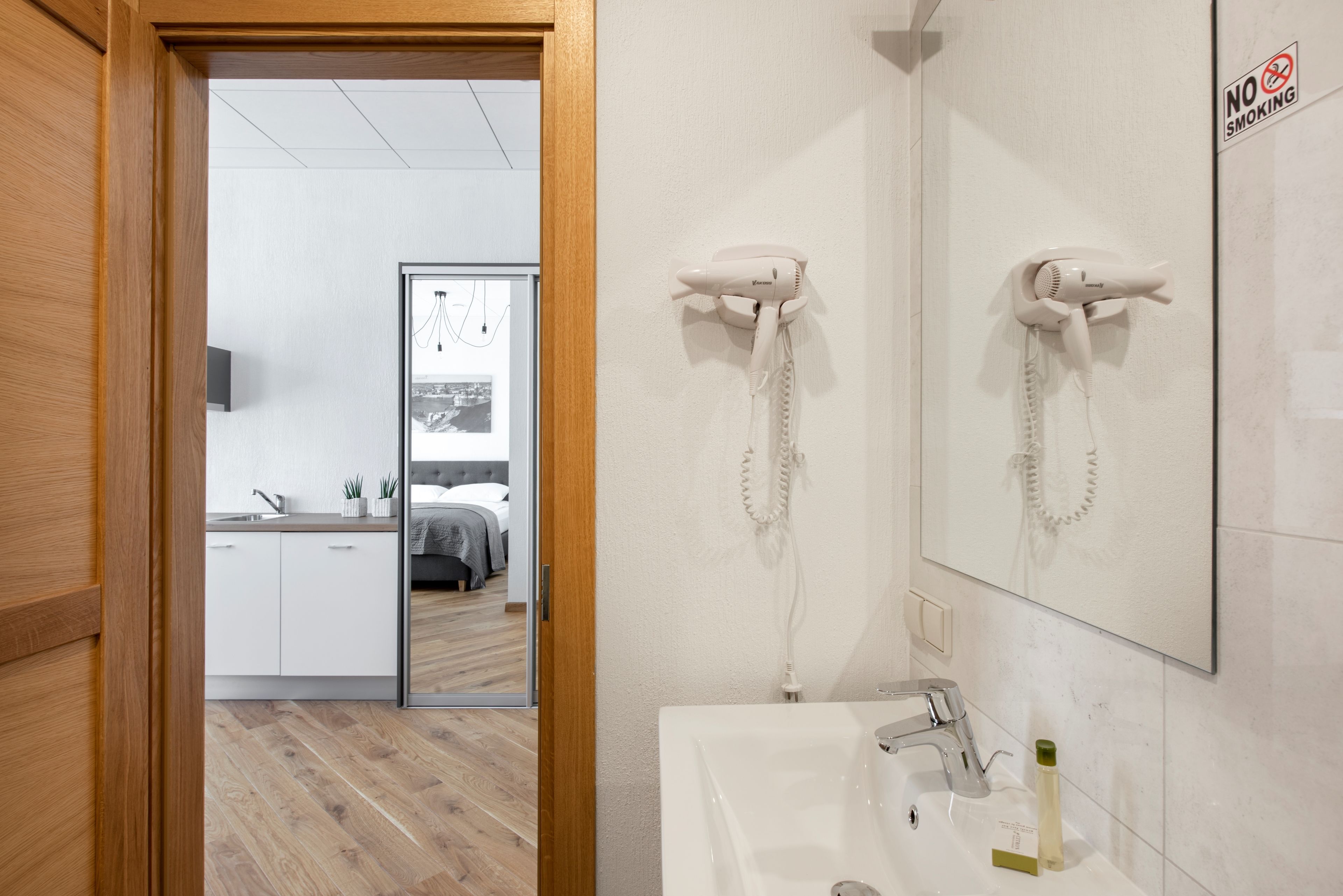 Una habitación de hotel con baño, una cama, un lavabo y un espejo.