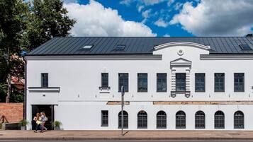 A white building with a dark roof, multiple windows, and a central entrance.