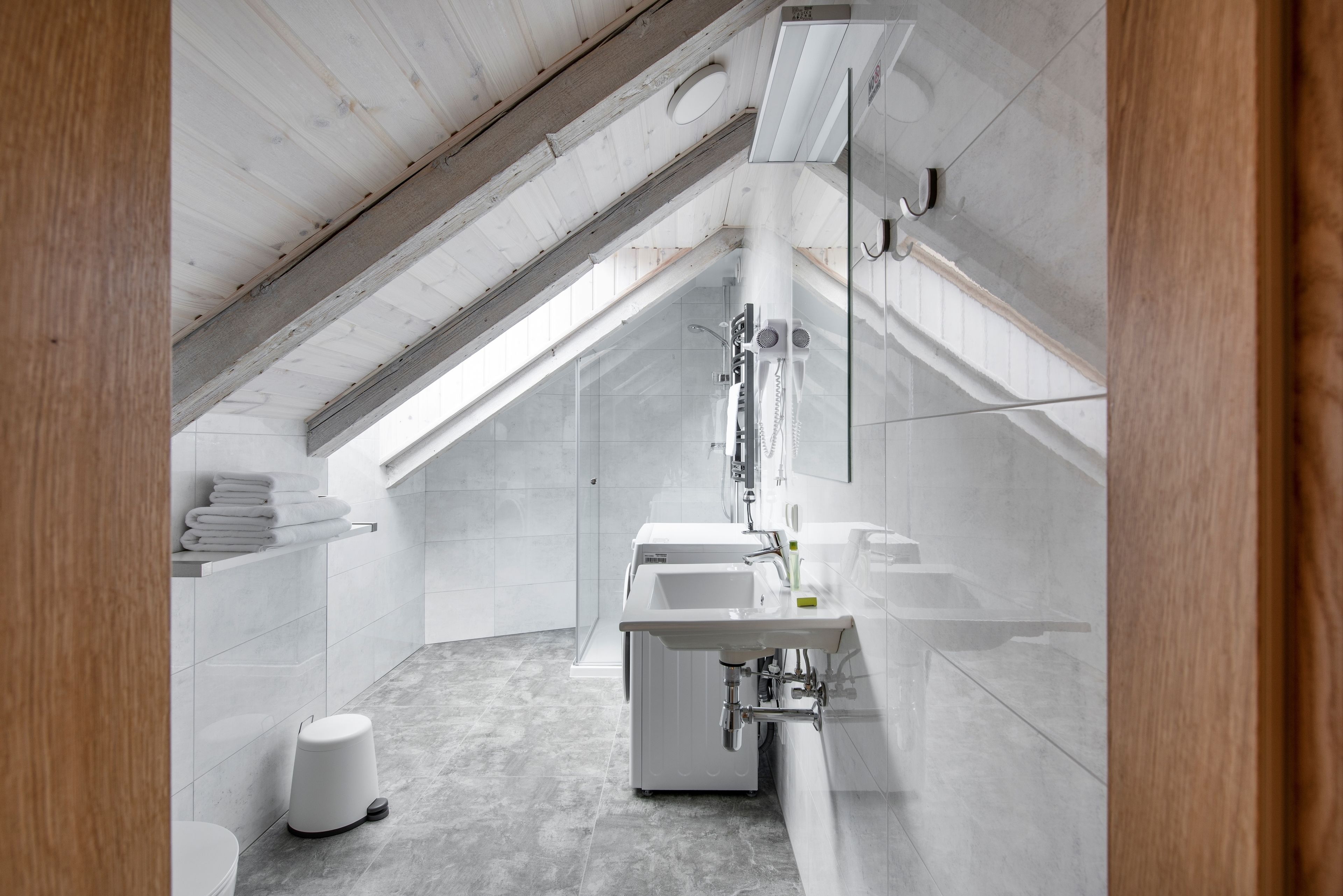 Un baño moderno con tragaluz, un lavamanos y un inodoro.